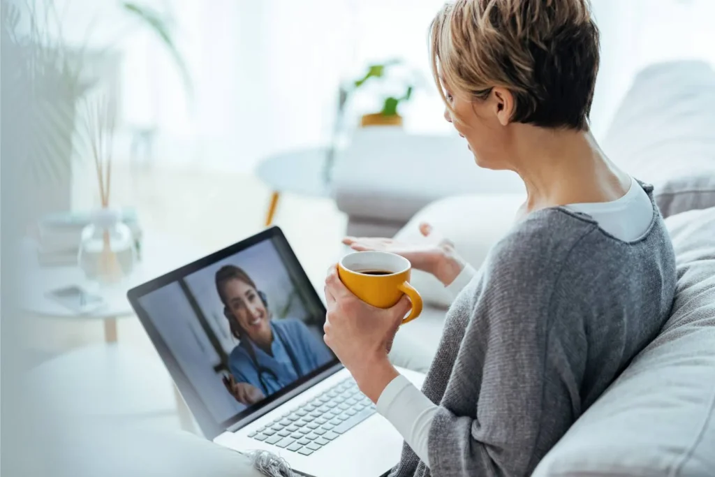 A woman attending an online meeting on her laptop for Personalized Telepsychiatry Care