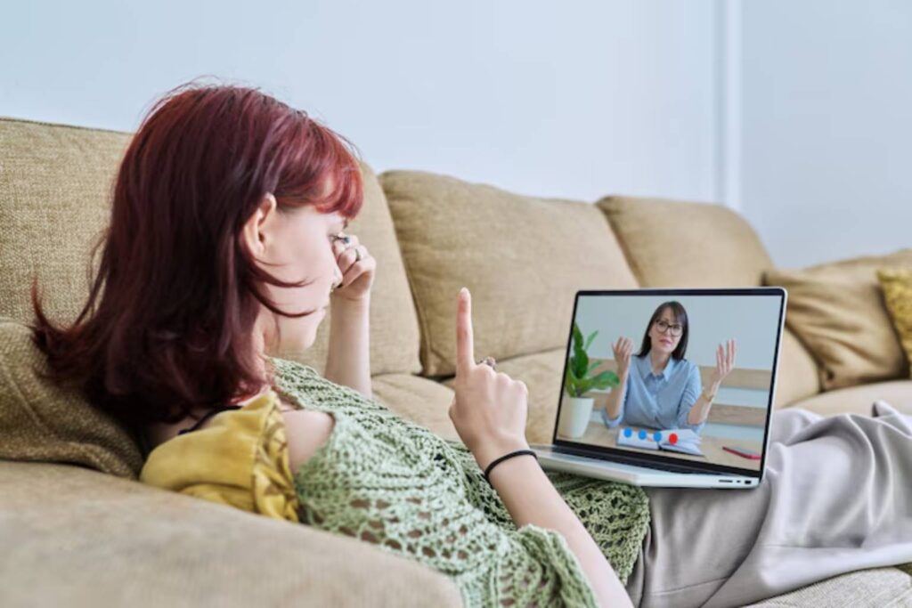 A woman attending an online meeting on her laptop for Telepsychiatry Care services