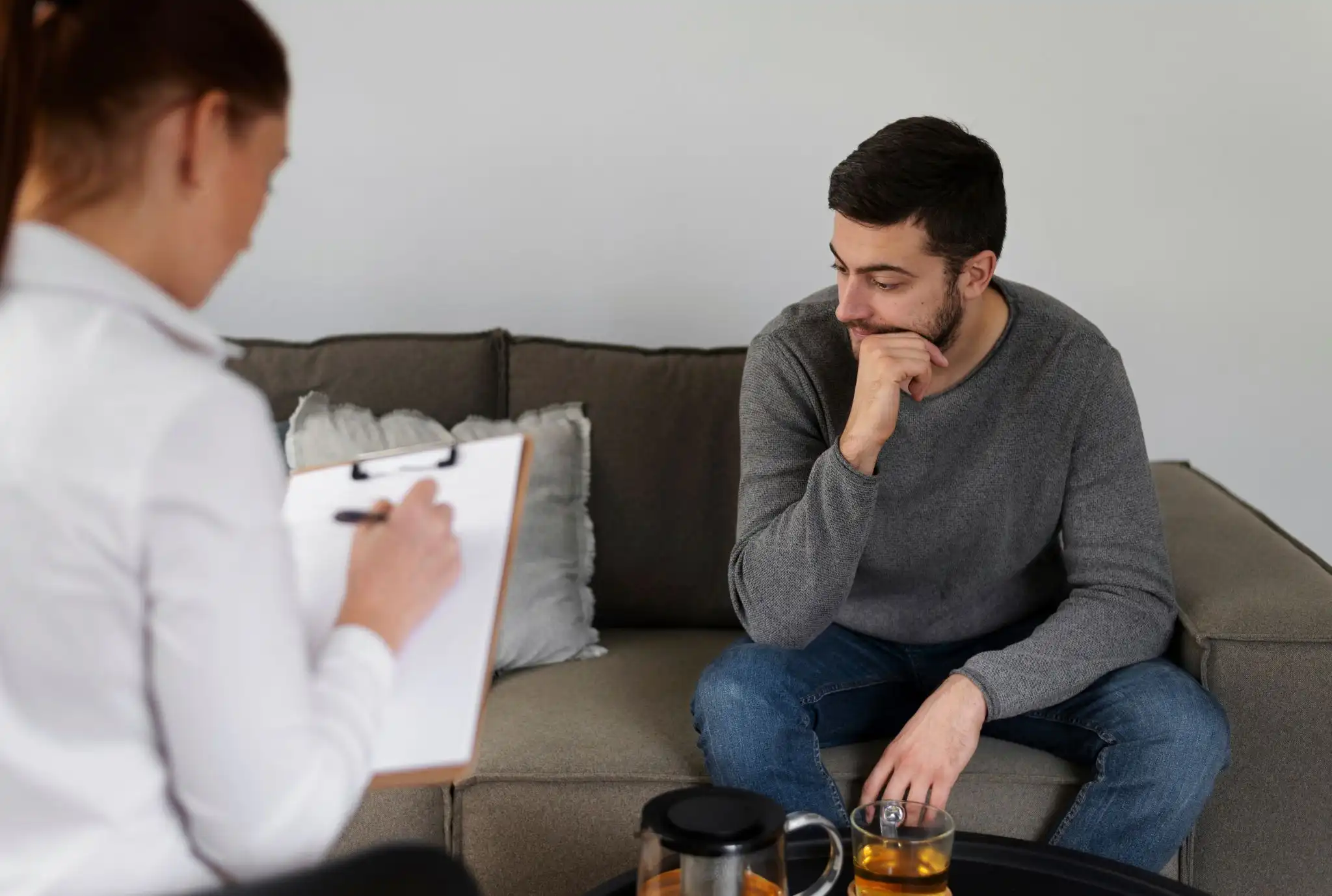 A thinking man and a woman sitting together in a consultation room