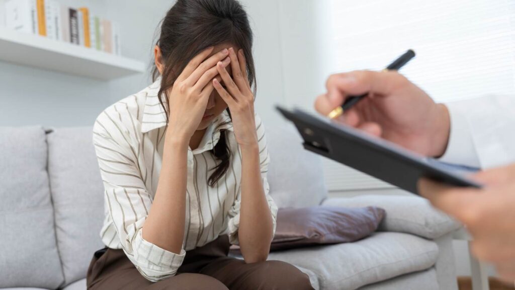 A stressed woman sitting on a sofa in a consultation room